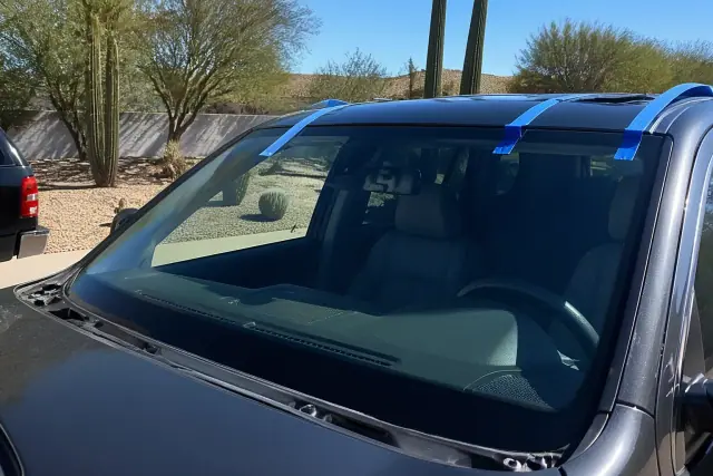 Newly installed car windshield with retention tape at a job site in Phoenix, AZ.