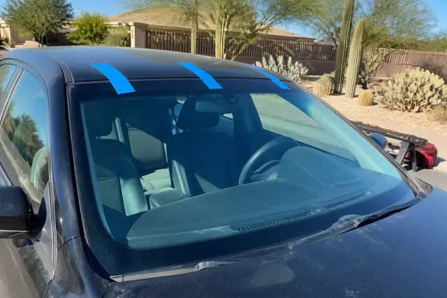 Newly installed car windshield with retention tape held in place at a jobsite in Phoenix, AZ.