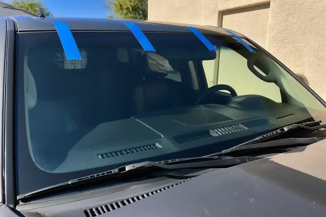 Newly installed laminated car windshield with retention tape on a vehicle in Phoenix, AZ.
