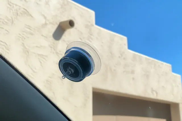 A resin injector tool repairing a star break on a vehicle windshield in Phoenix, AZ.
