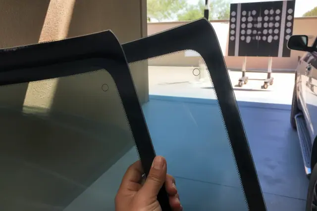Side-by-side comparison of OEM and aftermarket glass edge markings at a calibration bay in Phoenix, AZ.