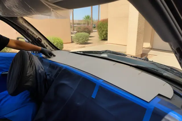 Windshield fit comparison using a masking template during a car glass replacement in Phoenix, AZ.