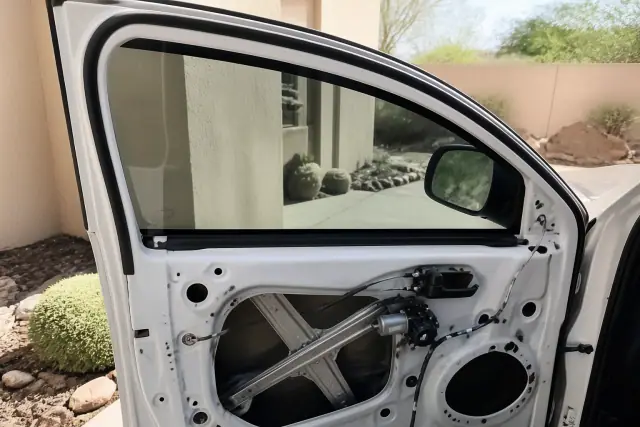 Passenger side window replacement on a vehicle at a job site in Phoenix, AZ, showing the door panel and window regulator.