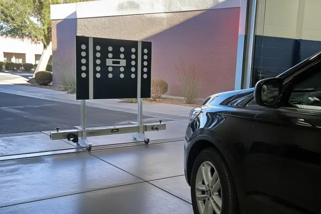 Radar calibration equipment aligned with a vehicle in a service bay in Phoenix, AZ.
