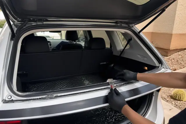 Technician replacing rear hatchback glass on a vehicle in Avondale, AZ.