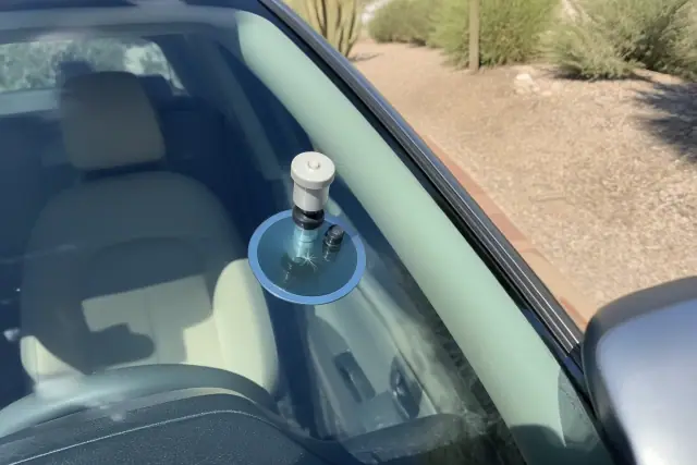 Resin injector tool repairing a star break on a vehicle windshield in Phoenix, AZ.