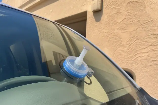 Resin injector tool repairing a windshield rock chip on a vehicle in Phoenix, AZ.