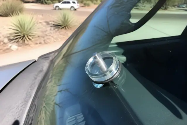 Resin injector tool attached to a star break on a vehicle windshield during a repair in Phoenix, AZ.