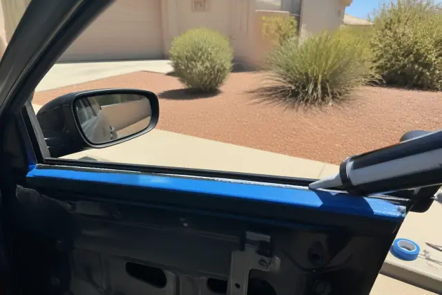 Technician preparing a car door frame for side window replacement in Phoenix, AZ.