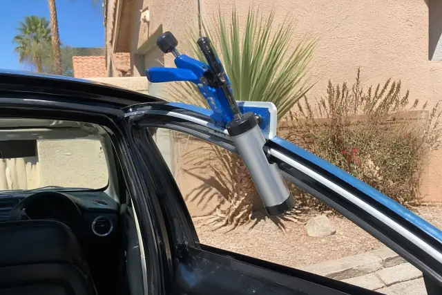 Technician applying adhesive to a clean car door frame for side window replacement in Peoria, AZ.