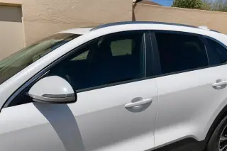 Newly installed side window glass on a car parked against a stucco wall in Phoenix, AZ.