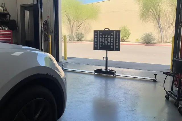 Digital calibration target stand set up in front of a vehicle in an open service bay in Phoenix, AZ.