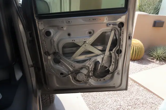 Car door panel removed showing the window regulator and electric motor at a repair job in Scottsdale, AZ.