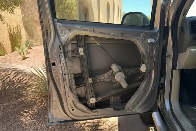 Car door with interior panel removed showing the window regulator and motor in Phoenix, AZ.