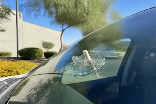Resin injector tool repairing a star chip on a vehicle windshield in Tempe, AZ.