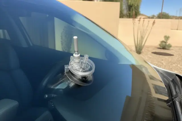 Resin injector tool repairing a star break on a car windshield in Glendale, AZ.