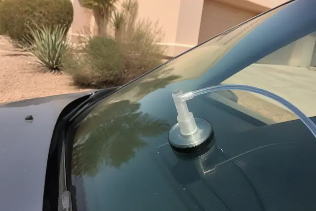 Resin injector tool repairing a star break on a vehicle windshield in Chandler, AZ.