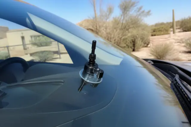 Close-up of a resin injector tool repairing a star break on a car windshield in Peoria, AZ.