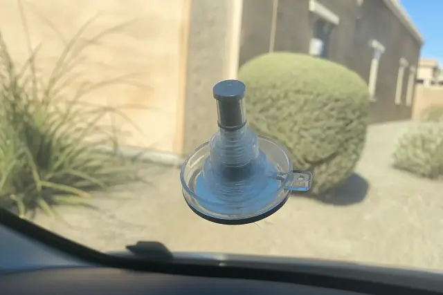 Resin injector tool repairing a star break on a vehicle windshield in Avondale, AZ.