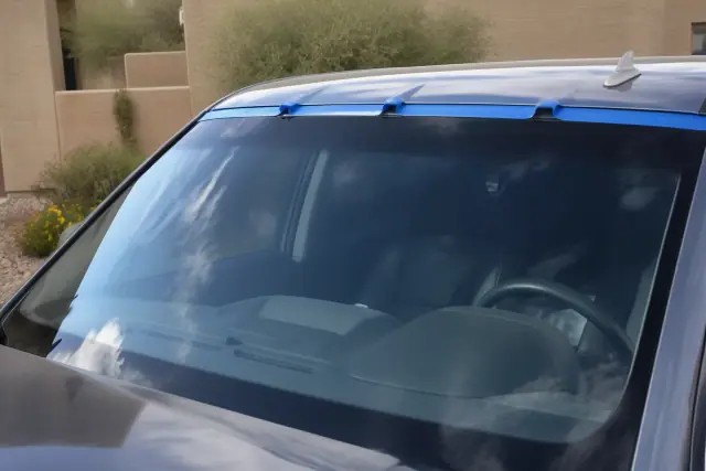 Newly installed windshield with retention tape on a vehicle at a job site in Avondale, AZ.