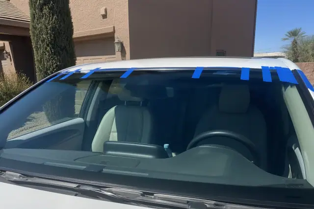 A newly installed car windshield with retention tape held in place at a jobsite in Gilbert, AZ.