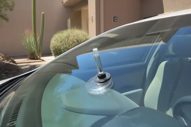 Close-up of a resin injector tool repairing a star break on a vehicle windshield in Phoenix, AZ.
