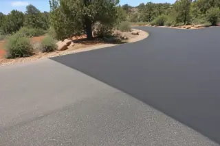Smooth butt joint between new asphalt overlay and older pavement in a Prescott, AZ high-desert landscape.