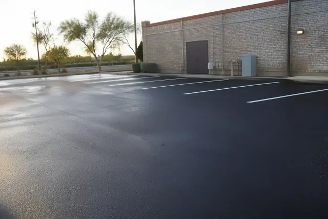 Freshly paved asphalt parking lot with white lines behind a restaurant in Glendale, AZ.