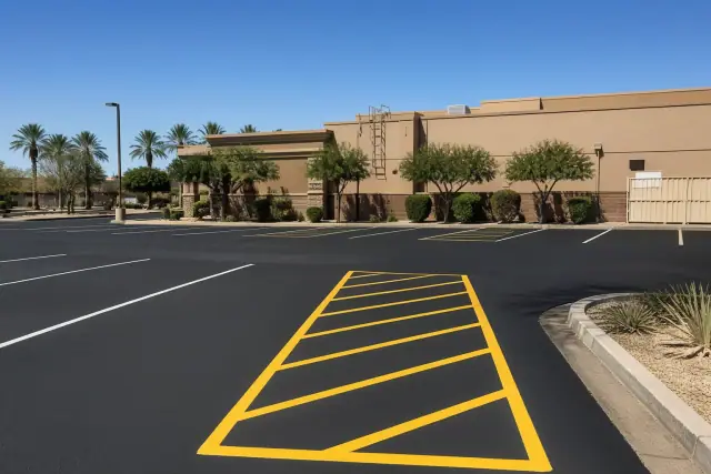 Freshly paved asphalt parking lot with new yellow and white striping at a restaurant in Gilbert, AZ.
