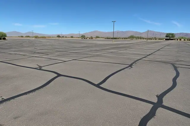 Newly sealed asphalt cracks in a large commercial parking lot in Mesa, AZ.