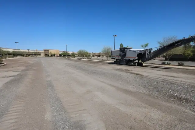 Freshly milled commercial parking lot with gravel base and heavy machinery in Queen Creek, AZ.