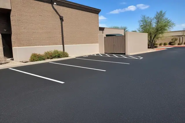 Freshly paved asphalt parking lot with crisp white lines behind a restaurant in Scottsdale, AZ.