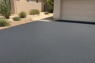 Fresh asphalt overlay texture next to a garage and desert landscaping at a home in Scottsdale, AZ.