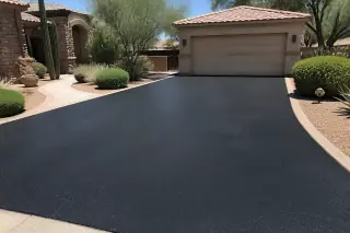 Dark, sealed asphalt driveway with crisp edges next to a detached garage and desert landscaping in Scottsdale, AZ.