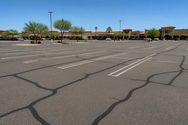 Freshly sealed asphalt cracks in a retail parking lot in Chandler, AZ.