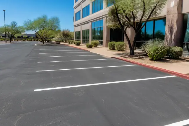 Freshly painted white parking stall lines on asphalt at an office complex in Scottsdale, AZ.