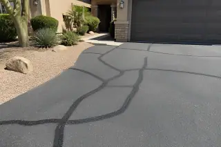 Sealed asphalt cracks in a residential driveway with crushed granite landscaping in Scottsdale, AZ.