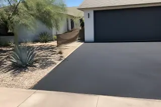 New asphalt driveway with desert agave plants next to a garage in Scottsdale, AZ.