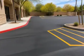 Fresh asphalt with painted markings by a storefront and blooming palo verde trees in Scottsdale, AZ.