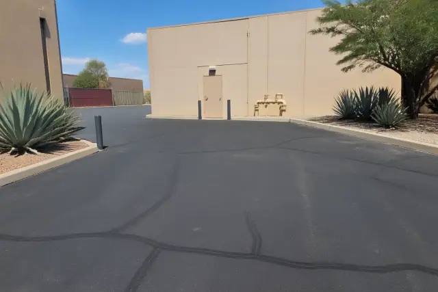 Freshly filled cracks on a commercial asphalt parking lot at a property in Tempe, AZ with desert landscaping.