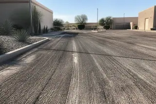 Cold-planed asphalt surface with parallel milling grooves and desert agave landscaping in Tempe, AZ.