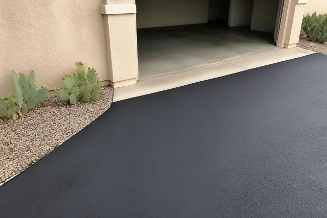 Newly paved asphalt driveway transition at a residential home in Peoria, AZ.