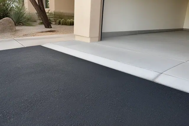 Newly repaired asphalt driveway transition at a suburban home in Tempe, AZ with desert landscaping.