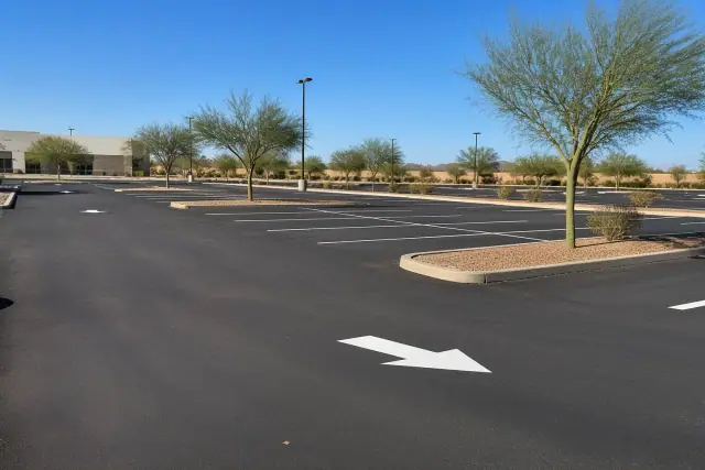 Newly paved parking lot with painted stall markers and desert landscaping in Tempe, AZ.
