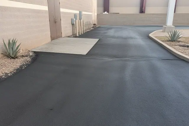 Freshly paved asphalt overlay and repaired cracks at a commercial building in Tempe, AZ.