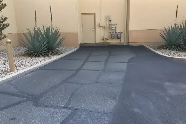 Freshly filled asphalt cracks and sealcoating at a commercial property in Tempe, AZ.