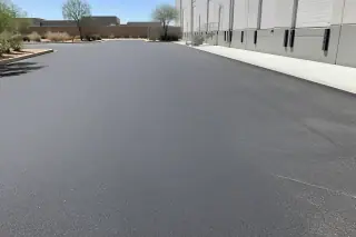 Uniform texture of a newly paved asphalt delivery zone under bright sun in Tempe, AZ.