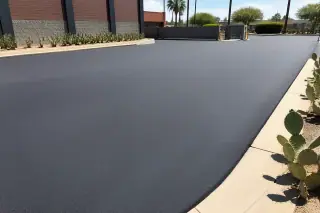 Freshly paved asphalt surface with crisp edges and prickly pear cacti at a loading zone in Tempe, AZ.