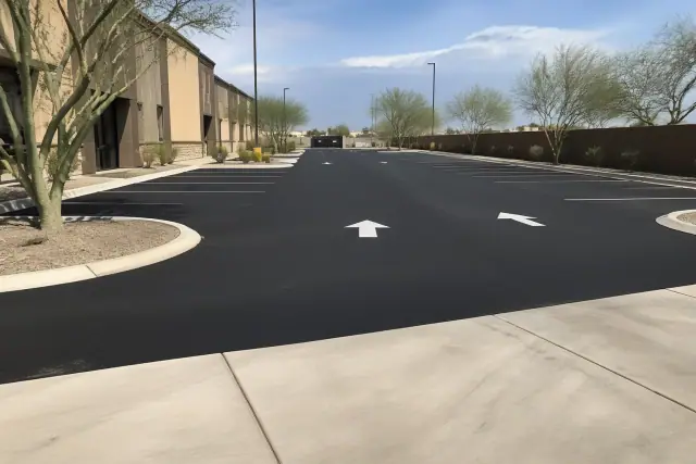 Fresh asphalt paving across a commercial parking lot.