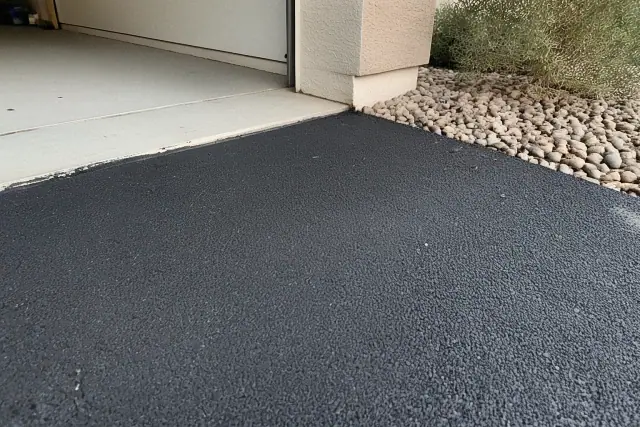 Compacted asphalt driveway transition at a home in Tempe, AZ with desert landscaping.